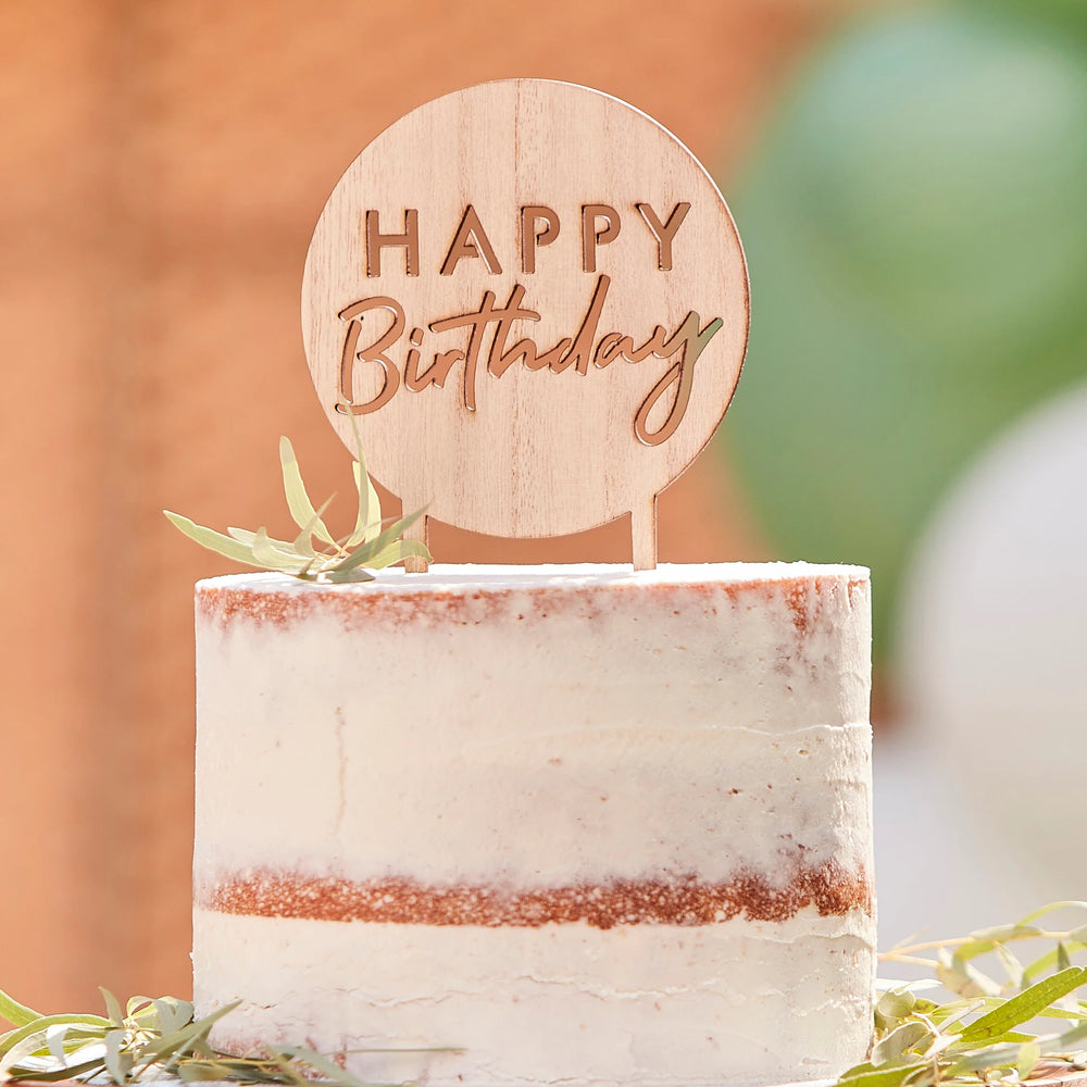 Wooden Happy Birthday cake topper displayed on a white birthday cake